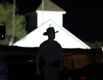 A law enforcement official walks past the First Baptist Church of Sutherland Springs, the scene of a mass shooting, Sunday, Nov. 5, 2017, in Sutherland Springs, Texas.