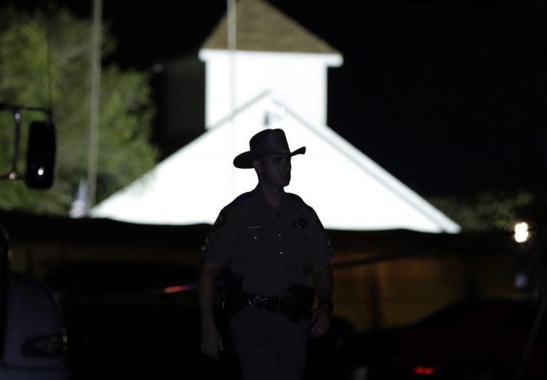 A law enforcement official walks past the First Baptist Church of Sutherland Springs, the scene of a mass shooting, Sunday, Nov. 5, 2017, in Sutherland Springs, Texas.