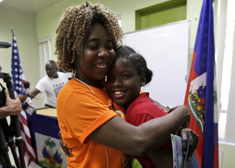 Ronyde Christina Ponthieux, 10, right, is hugged by Santcha Etienne, left, after speaking in favor of renewing Temporary Protected Status (TPS) for immigrants from Central America and Haiti now living in the United States, during a news conference Monday, Nov. 6, 2017, in Miami. Ponthieux's father came to the U.S. 18 years ago from Haiti and is here under TPS. The Department of Homeland Security is expected to rule soon on whether or not to renew the protected status.