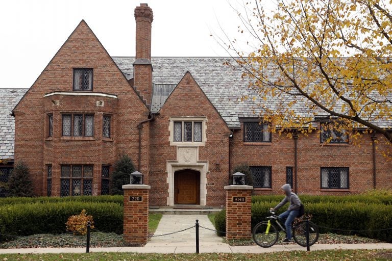 A bicyclist rides past Pennsylvania State University's shuttered Beta Theta Pi fraternity house Thursday, Nov. 9, 2017, in State College, Pa. Centre County, Pa., District Attorney Stacy Parks Miller announced Monday, Nov. 13, 2017, that more charges have been filed against fraternity brothers after investigators recovered deleted surveillance video footage recorded before the Feb. 4, 2017, death of 19-year-old Tim Piazza, of Lebanon, N.J., after a night of heavy drinking.