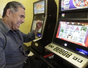 Chino Roberto Vasquez, owner of Chino's Pizzeria celebrates a winning hand on one of the new legal video poker machines, in his restaurant Tuesday, Oct. 9, 2012, in Justice, Ill. (M. Spencer Green/AP Photo)