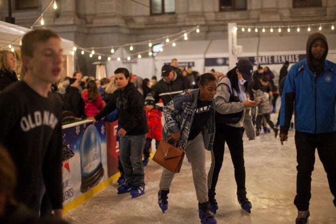 Ice skaters glide around the rink installed at Dilworth Park Friday evening during the Christmas tree lighting ceremony and opening of the Christmas Village. (Brad Larrison for WHYY)