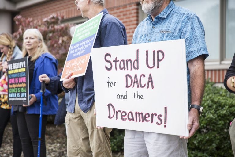 Community members held signs in support of a DREAM act and DACA recipients outside Rep. Glenn Thompson's Centre County office in September. (Min Xian/Keystone Crossroads)