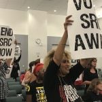 At the June 15 School Reform Commission meeting, demonstrators carried signs calling for the SRC to vote itself out of existence and return the school district to city control. (David Hornbeck/The Notebook)