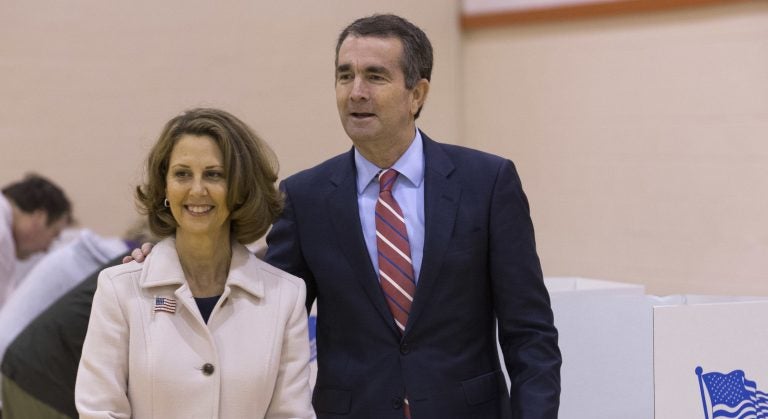 Democratic gubernatorial candidate Lt. Gov. Ralph Northam, right, and his wife, Pam, carry their ballots to the tally machine in Norfolk, Va.