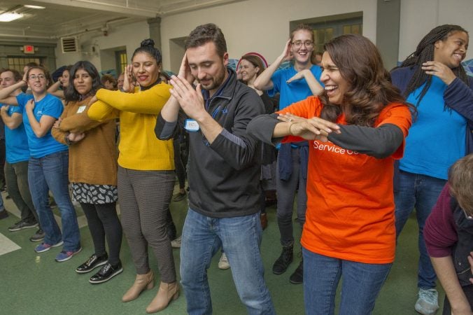 Volunteer Brenda Gorski, right leads refugees and volunteers in the Macarena. (Jonathan Wilson for WHYY)