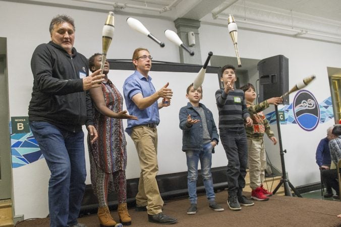 Ben Edoff, third from left, teaches refugees how to juggle. (Jonathan Wilson for WHYY)