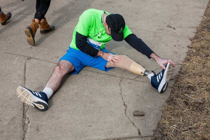 Evan Freiberg stretches before the Rothman Institute 8k Saturday. The 43-year-old is diagnosed with leiomyosarcoma, a form of cancer, and competed after losing the bottom portion of his left leg to the disease. (Brad Larrison for WHYY)