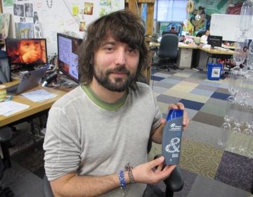 TerraCycle CEO Tom Szaky shows a shampoo bottle made with recycled plastic collected from beaches and oceans. (Phil Gregory/WHYY)