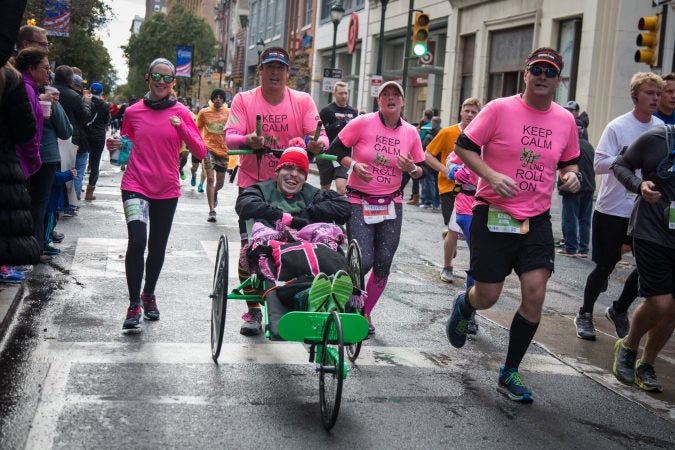 Dave Goldstein, of South Jersey, pushes his son, Josh, 22, as they run for Ainsley's Angels at the 23rd annual Philadelphia Marathon on Sunday, November 19th, 2017.