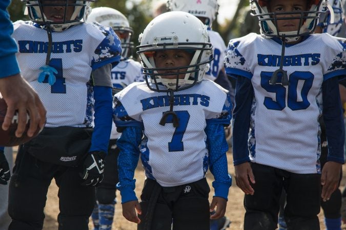 Zaid Duncan, 4, center, lines up to start his football game.