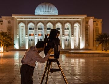 man looking through telescope in Middle East