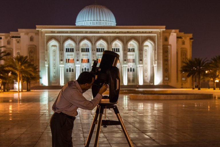 man looking through telescope in Middle East