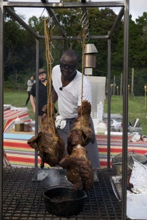 Chef Shola Olunloyo slow roasted meat lamb and pork over fire