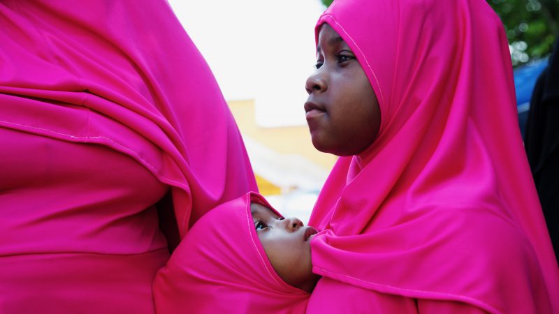 Two sisters watch Eid al-Fitr festivities at Clara Muhammad Square in Philadelphia Sunday, June 25, 2017. (Annie Risemberg for Newsworks)