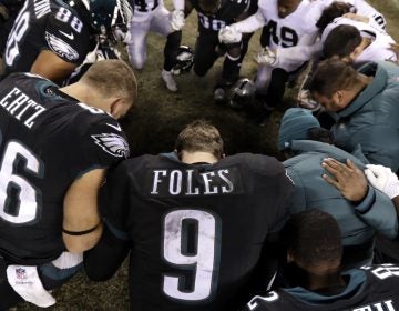 Philadelphia Eagles' Nick Foles (9) kneels with other players after an NFL football game against the Oakland Raiders
