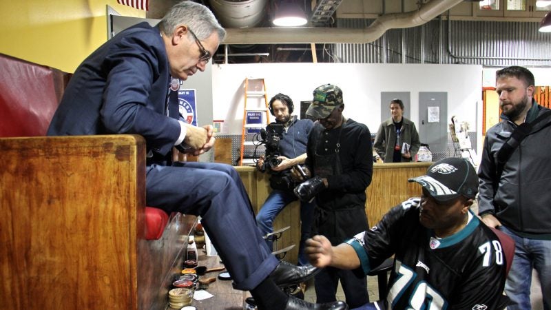 District attorney candidate Larry Krasner (left) stops for a shoe shine at Reading Terminal Market while campaigning on the eve of the 2017 election. (Emma Lee/WHYY)