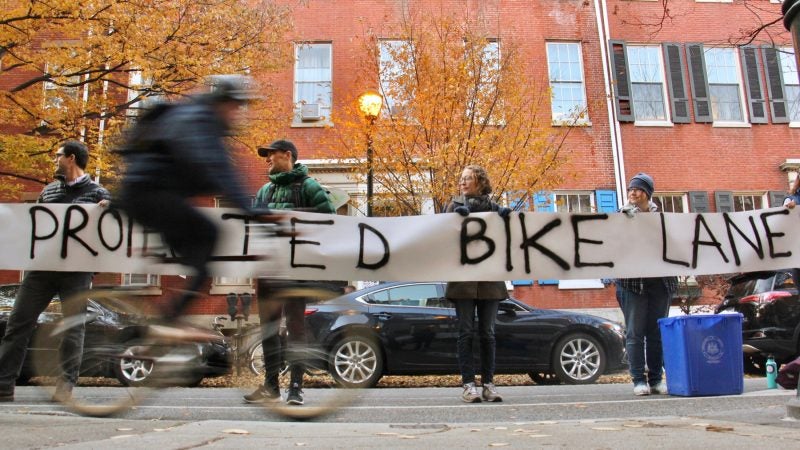 Protesters demanding protected bike lanes form a human barrier stretching for two blocks along Spruce Street near 11th Street, where a cyclist was killed by a garbage truck the previous morning.