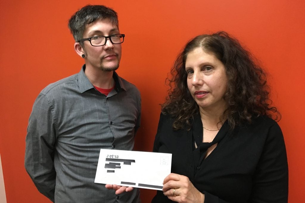 Adrian Lowe (left), staff attorney with Aids Law Project and Ronda Goldfein, attorney and executive director of the Aids Law Project, hold a letter that was sent to thousands of Aetna members, revealing their HIV positive status through an over-large mailing window.