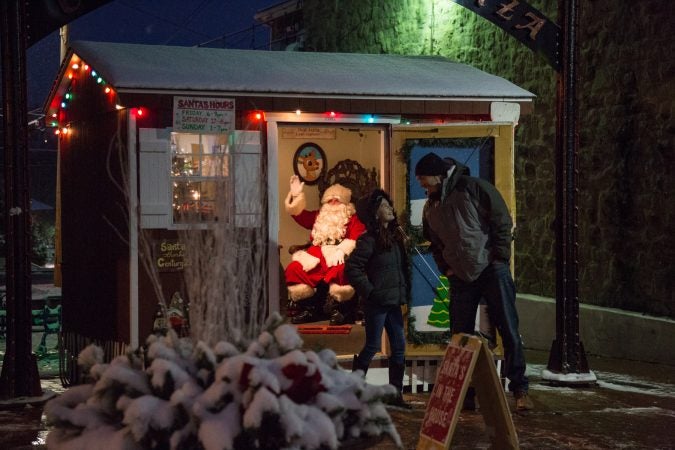 A girl and her father share a laugh after a visit with Santa at the 14th Annual Firebird Festival in Phoenixville, Pennsylvania. (Emily Cohen for WHYY)