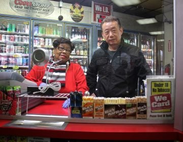 Olney Steak and Beer owner O. J. Yoo stands behind a plexiglass window with employee Sylvia Combs.