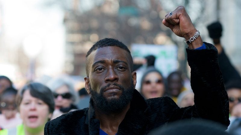 Prentice Bush raises his fist as he joins a crowd of hundreds protesting right-wing extremism at a march in Philadelphia, on Martin Luther King Jr. Day. (Bastiaan Slabbers for WHYY)