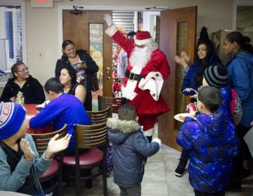 Santa makes an appearance at a  Christmas party for Puerto Rican families at the office of Association of Puerto Ricans In March, on Philadelphia Saturday, for about 20 families displaced from Puerto Rico after hurricane Maria. (Bastiaan Slabbers for WHYY)