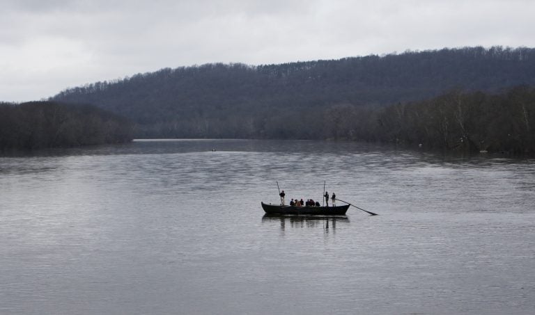 FILE- In this Dec. 25, 2015, file photo, a group of Revolutionary War re-enactors row a Durham boat during the re-enactment of Washington crossing the Delaware River, in Washington Crossing, Pa. Re-enactors might not be able to make their annual Christmas Day trip across the Delaware River between Pennsylvania and New Jersey because low water levels make it impossible for them to navigate their wooden Durham boats.