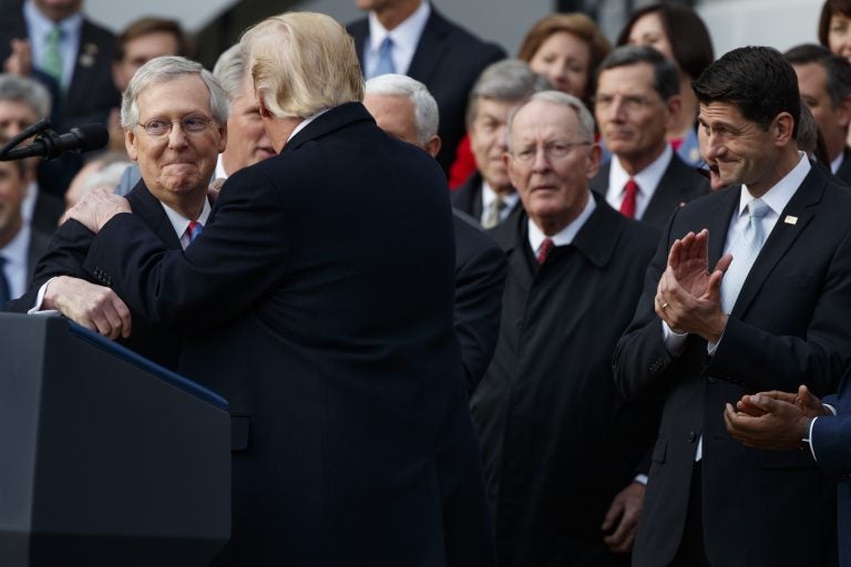 Speaker of the House Paul Ryan, R-WIs., right, applauds as President Donald Trump hugs Senate Majority Leader Mitch McConnell, R-Ky., as he speaks during an event on the South Lawn of the White House in Washington, Wednesday, Dec. 20, 2017, to acknowledge the final passage of tax overhaul legislation by Congress.