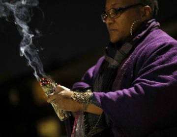 In this Dec. 11, 2017 photo, Erricka Bridgeford burns sage as she performs a ceremony near the scene of a homicide in Baltimore. Bridgeford lost a brother, a stepson, and three cousins to gun violence. (Patrick Semansky/AP Photo)