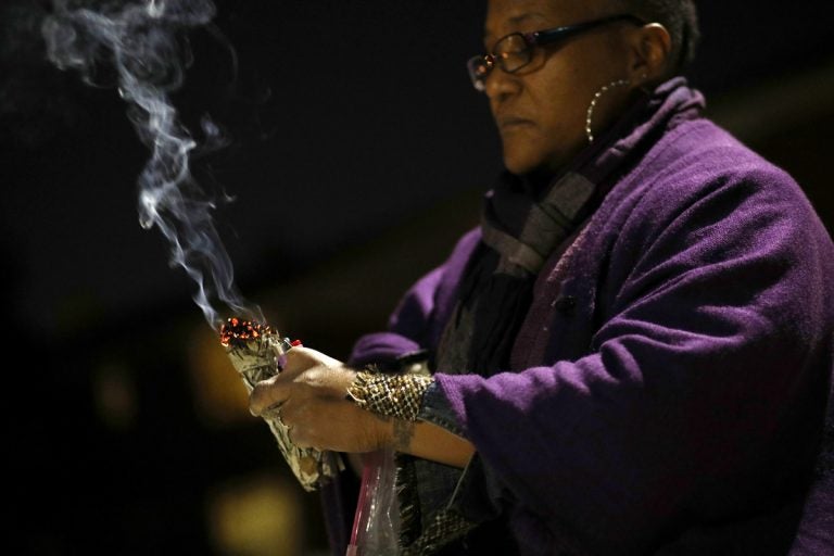 In this Dec. 11, 2017 photo, Erricka Bridgeford burns sage as she performs a ceremony near the scene of a homicide in Baltimore. Bridgeford lost a brother, a stepson, and three cousins to gun violence. (Patrick Semansky/AP Photo)