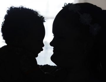 A mother holds her son in her apartment, Tuesday, Aug. 8, 2017, in Indianapolis. The baby was born in 2016, and it took a month for doctors to wean him off the heroin his mother exposed him to. He is in foster care now and his mother is fighting to get him back. (Darron Cummings/AP Photo)