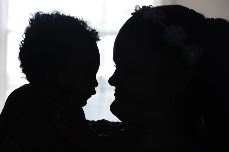 A mother holds her son in her apartment, Tuesday, Aug. 8, 2017, in Indianapolis. The baby was born in 2016, and it took a month for doctors to wean him off the heroin his mother exposed him to. He is in foster care now and his mother is fighting to get him back. (Darron Cummings/AP Photo)