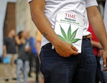 Michael Cole of Clairton, Pa., holds a Time magazine while waiting in line in downtown McKeesport, Pa., to attend a Medical Marijuana Job Fair, Thursday, July 27, 2017. (Gene J. Puskar/AP Photo)