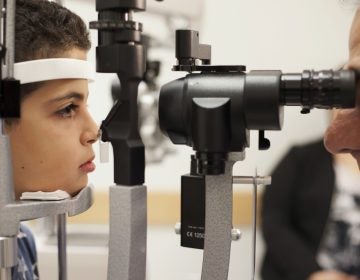 In this Oct. 4, 2017, file photo, Dr. Albert Maguire, right, checks the eyes of Misa Kaabali, 8, at the Children's Hospital of Philadelphia. Misa was 4-years-old when he received his gene therapy treatment. On Tuesday, Dec. 19, 2017, the Food and Drug Administration approved the therapy which improves the vision of patients with a rare form of inherited blindness, another major advance for the burgeoning field of genetic medicine. (Bill West/AP Photo, file)