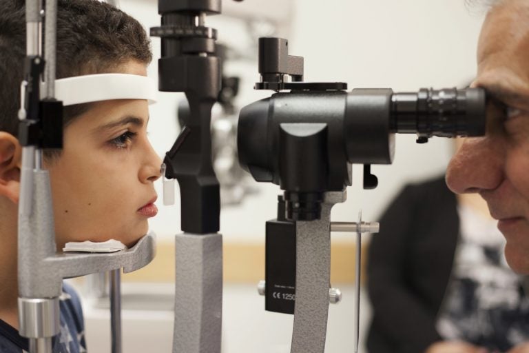 In this Oct. 4, 2017, file photo, Dr. Albert Maguire, right, checks the eyes of Misa Kaabali, 8, at the Children's Hospital of Philadelphia. Misa was 4-years-old when he received his gene therapy treatment. On Tuesday, Dec. 19, 2017, the Food and Drug Administration approved the therapy which improves the vision of patients with a rare form of inherited blindness, another major advance for the burgeoning field of genetic medicine. (Bill West/AP Photo, file)