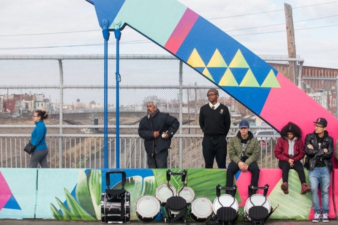 Community members and students from Kensington High School for the Creative and Performing Arts stood and walked on the B Street Bridge during a dedication ceremony for the recently-completed mural on the bridge. (Brad Larrison for WHYY)