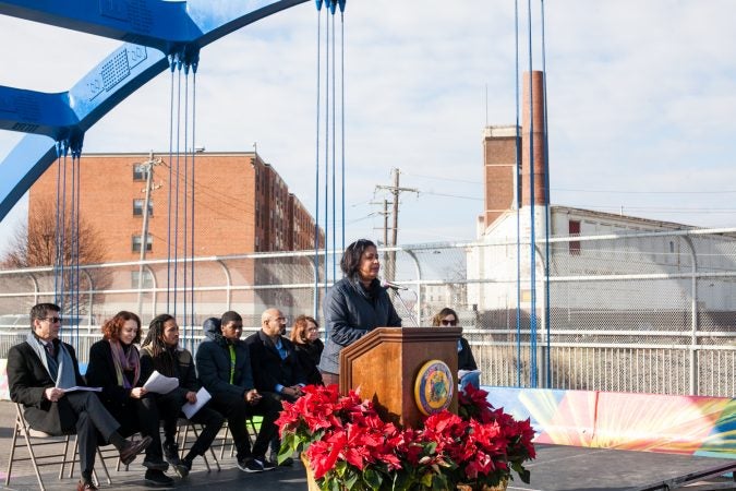 City Council Woman for the 7th District, Maria Quinones-Sanchez, spoke at the dedication ceremony for a new mural on the B Street Bridge in Kensington Tuesday. (Brad Larrison for WHYY)