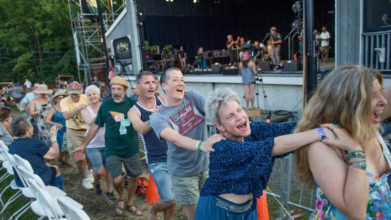 Audience members form a conga line as Baile An Salsa performs on the stage at the Philadelphia Folk Festival. (Jonathan Wilson for Newsworks)