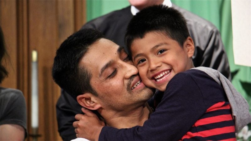 Javier Flores embraces his son, Javier, 5. Under threat of deportation, Flores, a father of three, found sanctuary at Arch Street United Methodist Church for more than 10 months. He left on Oct. 11, 2017, when authorities decided to defer action while his visa application is considered. (Emma Lee/WHYY)