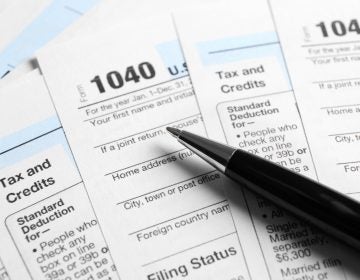 Individual Tax Return Forms and pen on table