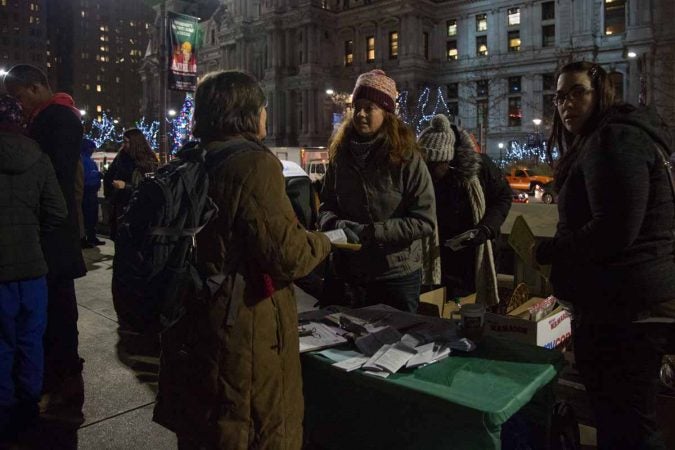 A volunteer works to collect signatures in support of legislation that supports the homeless population of Philadelphia. (Emily Cohen for WHYY)