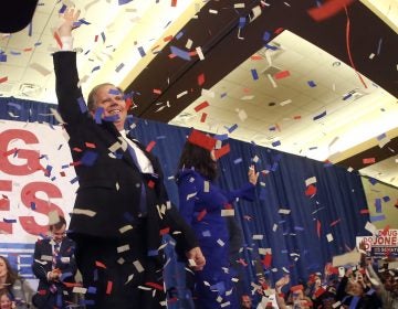 Democrat Doug Jones and his wife Louise wave to supporters