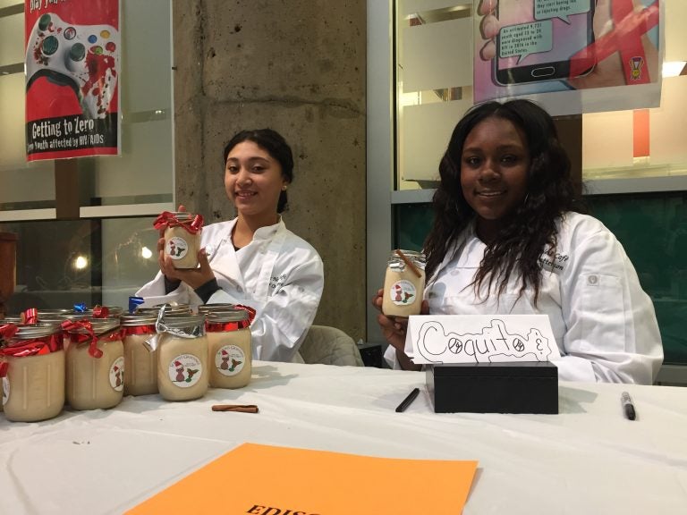 Keilina Collazo (left) and Elima Patterson, students at Edison High School, offer their homemade coquito for sale. (Avi Wolfman-Arent/WHYY). 