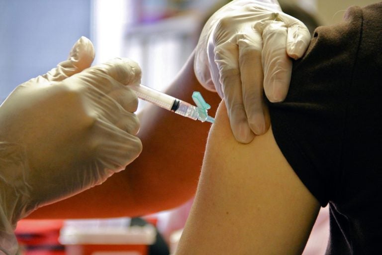 A woman gets an injection in her upper arm