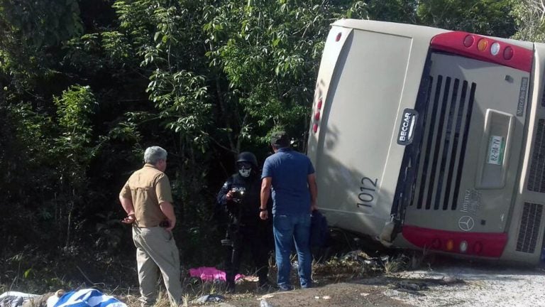 Police and paramedics at the scene of a tourist bus crash in eastern Mexico Tuesday. Most of the passengers on board were had arrived aboard cruise ships and were going to view Mayan ruins.