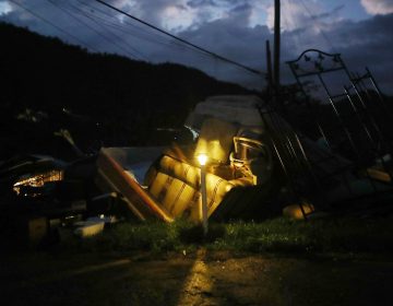 A donated solar lamp in a driveway illuminates storm debris still waiting to be collected earlier this week in Morovis, Puerto Rico. (Mario Tama/Getty Images)