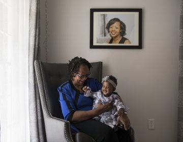 Wanda Irving holds her granddaughter, Soleil, in front of a portrait of Soleil's mother, Shalon, at her home in Sandy Springs, Ga. Wanda is raising Soleil since Shalon died of complications due to hypertension a few weeks after giving birth. (Becky Harlan/NPR)