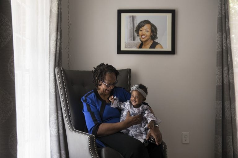 Wanda Irving holds her granddaughter, Soleil, in front of a portrait of Soleil's mother, Shalon, at her home in Sandy Springs, Ga. Wanda is raising Soleil since Shalon died of complications due to hypertension a few weeks after giving birth. (Becky Harlan/NPR)