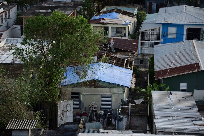 In this Nov. 15, 2017 photo, some roofs damaged by Hurricane Maria have awnings installed in El Gandúl neighborhood, in San Juan, Puerto Rico. A newly created Florida company with an unproven record won more than $30 million in contracts from the Federal Emergency Management Agency to provide emergency tarps and plastic sheeting for repairs to hurricane victims in Puerto Rico. Bronze Star LLC never delivered those urgently needed supplies, which even months later remain in demand on the island.  (AP Photo/Carlos Giusti)